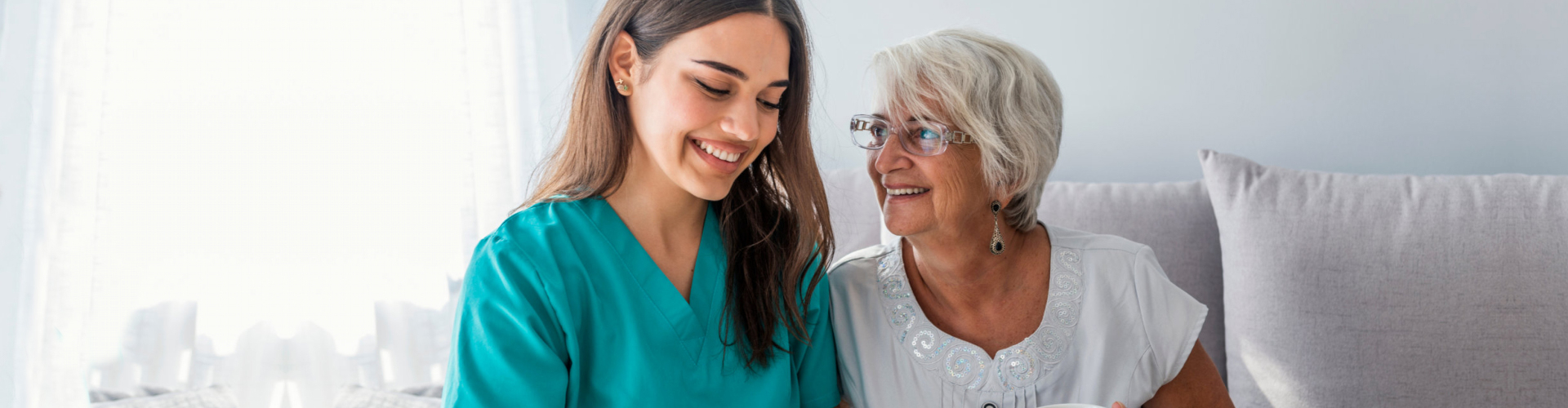 caregiver laughing with elderly woman